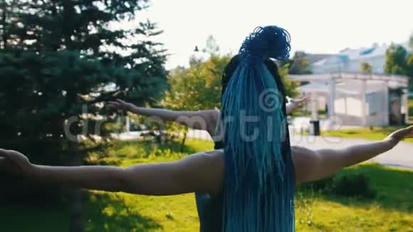两个年轻的女人在公园里和她们的教练一起做瑜伽举起双手一个女人带着蓝色的恐惧视频的预览图