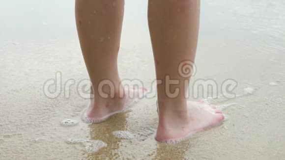 沙滩上的人的双腿溅起水波视频的预览图