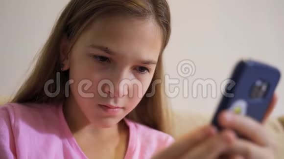 年轻女孩手里拿着智能手机坐在客厅的沙发上视频的预览图