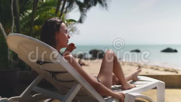躺在海边晒太阳的轻松女人视频的预览图