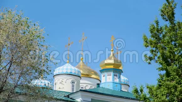 东正教十字架上的金色圆顶或古铜色再次蓝色晴朗的天空库存录像为所有人的荣誉建造美丽的教堂视频的预览图