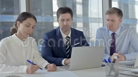 中年商人在手提电脑上与助理分享报告视频的预览图