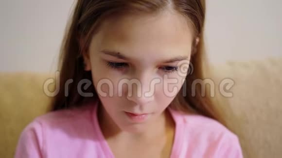 年轻女孩手里拿着智能手机坐在客厅的沙发上视频的预览图