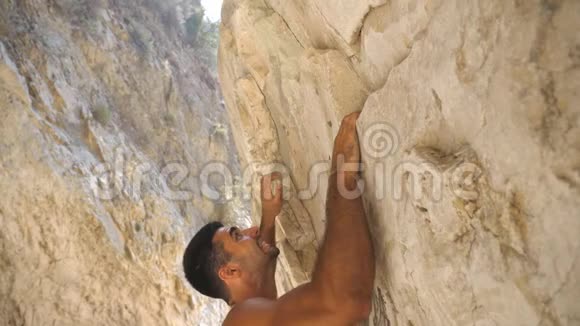 年轻肌肉男攀岩的侧视强壮的人在摇滚巅峰上奋起努力登山者视频的预览图
