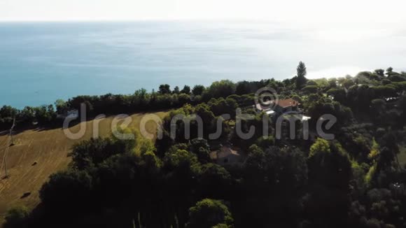 在晴朗的晴天在意大利无人机飞过美丽的绿色地中海海滨山丘飞向令人惊叹的房子视频的预览图