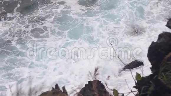 海浪在岩石海岸上破碎形成海泡视频的预览图
