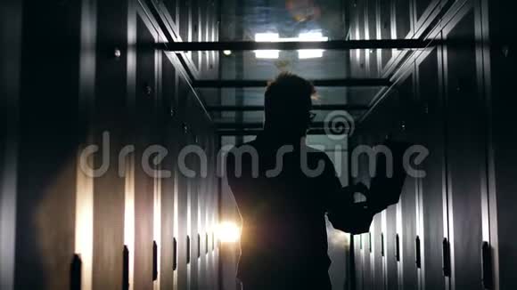 计算机系统安全专家人们站在一个黑暗的房间里用笔记本电脑工作视频的预览图
