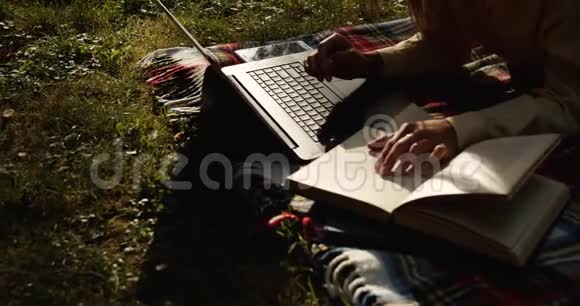 在公园对比灯光下用笔记本电脑打字的女人视频的预览图