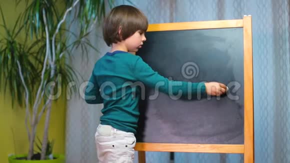 快乐的孩子用粉笔在黑板上画画视频的预览图
