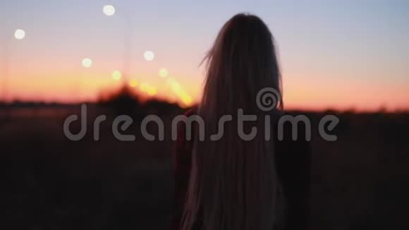 黄昏日落后妇女在田野散步的剪影视频的预览图