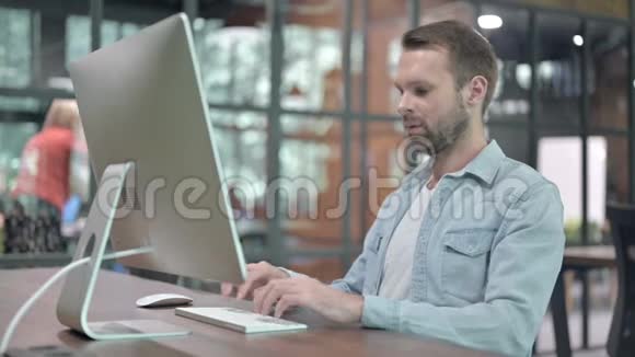 生病的年轻人在电脑工作时咳嗽视频的预览图
