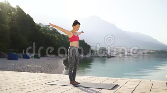 早上穿运动服在海边做瑜伽运动的美女视频的预览图