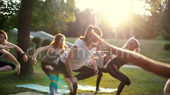 一群身穿运动服的年轻女子单腿站在瑜伽位置视频的预览图