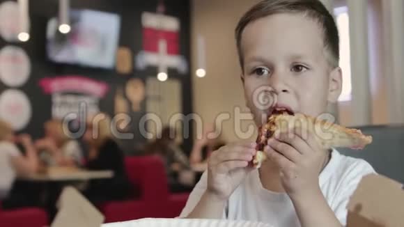 很漂亮小男孩在咖啡馆里吃披萨视频的预览图
