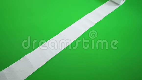 一卷卫生纸在绿色地板上展开视频的预览图