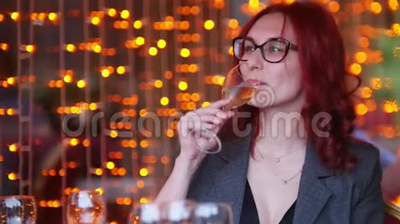 一个女人坐在餐厅的桌子旁喝着香槟视频的预览图