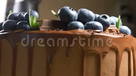 带蓝莓绿叶和巧克力的棕色蛋糕视频的预览图