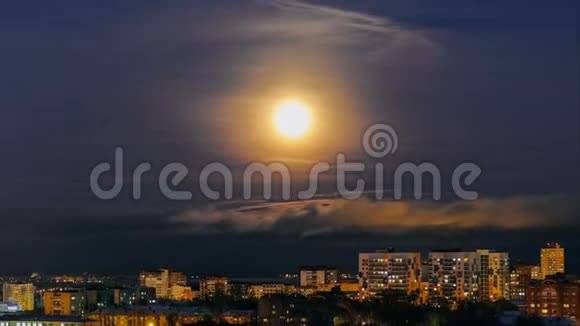 明亮的月亮照耀着多云的天空照亮了城市景观视频的预览图