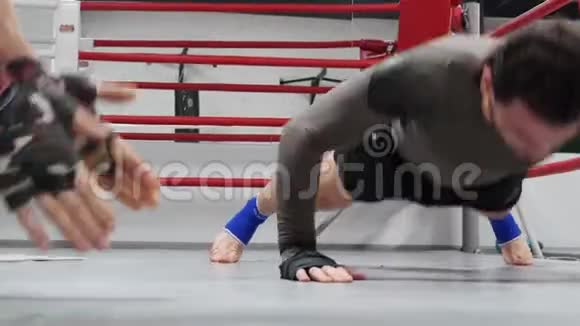 拳击手在环边训练时用拍子在地板上做俯卧撑视频的预览图