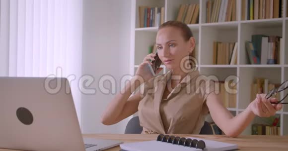开朗的女商人在手提电脑前在办公室里轻松地玩着眼镜视频的预览图