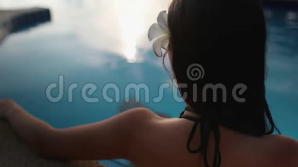 在酒店附近的度假游泳池放松的女人视频的预览图
