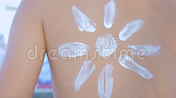 妈妈在海滩上给女儿的肩膀涂抹防晒霜视频的预览图