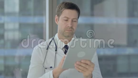 医生在平板上滚动使用互联网视频的预览图