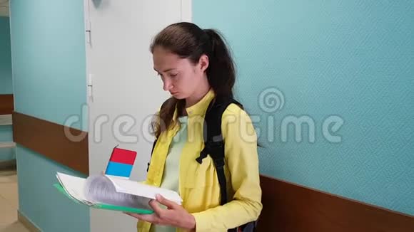 那个黑发女孩站在学校的墙边等待她的转身翻过报纸视频的预览图