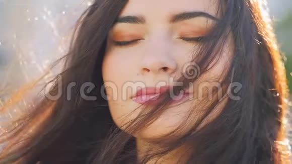 宁静的美放松的女人晒太阳发风视频的预览图