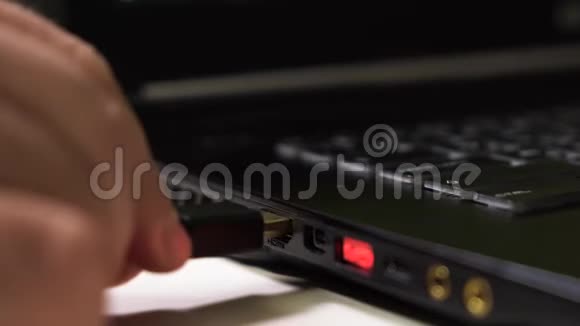 关闭男性手连接红色HDMI电缆到笔记本电脑与发光红色USB端口视频的预览图