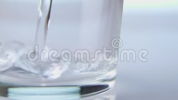 将新鲜纯净水倒入桌上的玻璃杯中健康饮食理念在白色背景上隔离慢动作视频的预览图