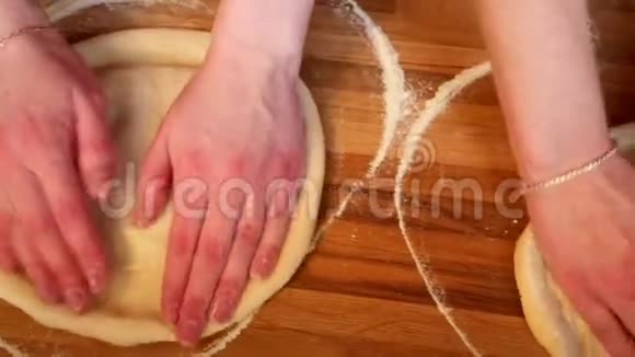 在糕点厨房里用女性的双手做披萨面团视频的预览图
