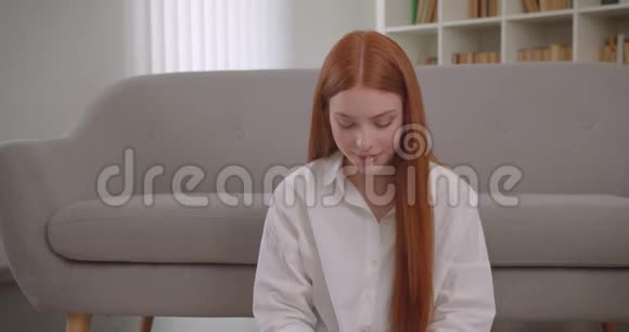 一位年轻可爱的红头发女性的特写镜头她在手机上打了个视频电话坐在镜头前摆姿势视频的预览图