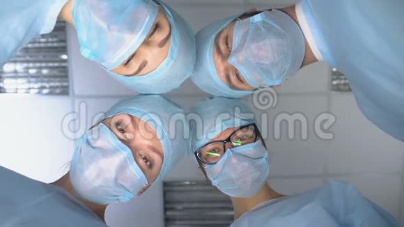 微笑的外科医生团队面对POV患者在手术麻醉后醒来视频的预览图
