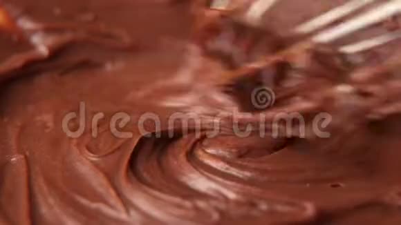 用搅拌器混合融化的液体巧克力关闭液体热巧克力漩涡视频的预览图
