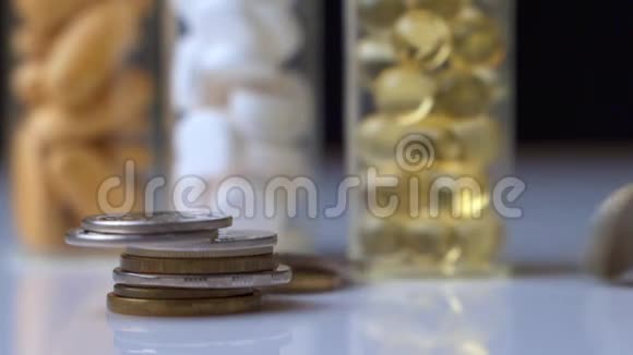 昂贵药物的概念硬币掉下来三小瓶有色药丸视频的预览图