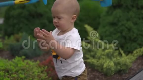 小男孩的儿子在一个有玩具的花园里被砍家庭价值观温暖的颜色夏天的场景视频的预览图