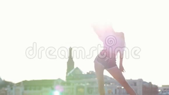 穆拉托年轻的女人卷发站在屋顶上表演迷人的舞蹈视频的预览图