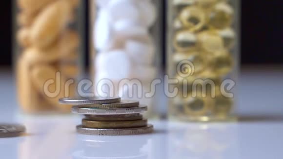昂贵药物的概念硬币掉下来三小瓶有色药丸视频的预览图