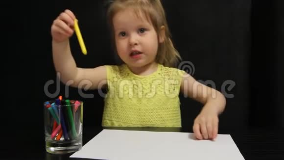 小女孩用黄色铅笔在纸上画太阳视频的预览图