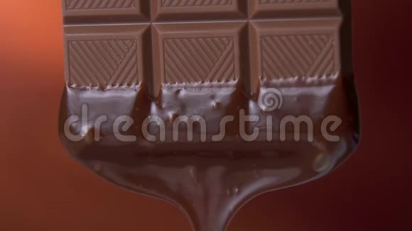 巧克力棒与融化的黑巧克力滴在棕色背景上视频的预览图