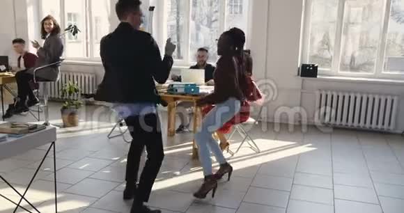 快乐的多民族办公室公司经理在现代健康的工作场所聚会上做有趣的疯狂舞蹈庆祝成功视频的预览图
