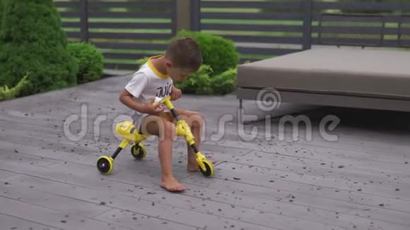 小男孩儿子骑着三轮自行车看起来像蜜蜂家庭价值观温暖的颜色夏天的场景视频的预览图