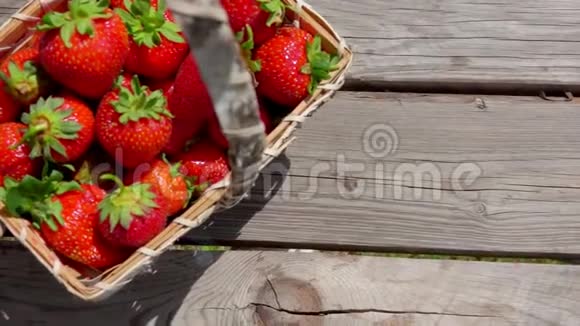 甜草莓落在篮子附近的桌子上视频的预览图