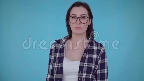 沮丧的年轻女子站在蓝色背景上手里拿着纸巾痔疮疼痛的概念近在咫尺视频的预览图