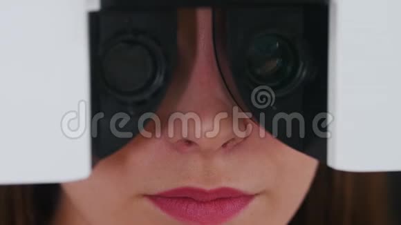 眼科治疗一名年轻女子她的嘴唇明亮粉红色用特殊验光法检查视力视频的预览图