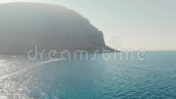 大海上的大山一艘船在水中飞驰日落前的时间空中无人机射击视频的预览图