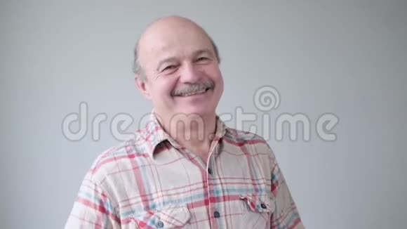 微笑的西班牙裔老人看着镜头视频的预览图