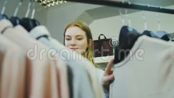 女顾客在服装店的货架上查看商品视频的预览图