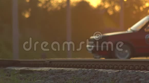 在阳光明媚的日落背景下汽车穿过铁路交叉路口铁路上的危险背景复制视频的预览图
